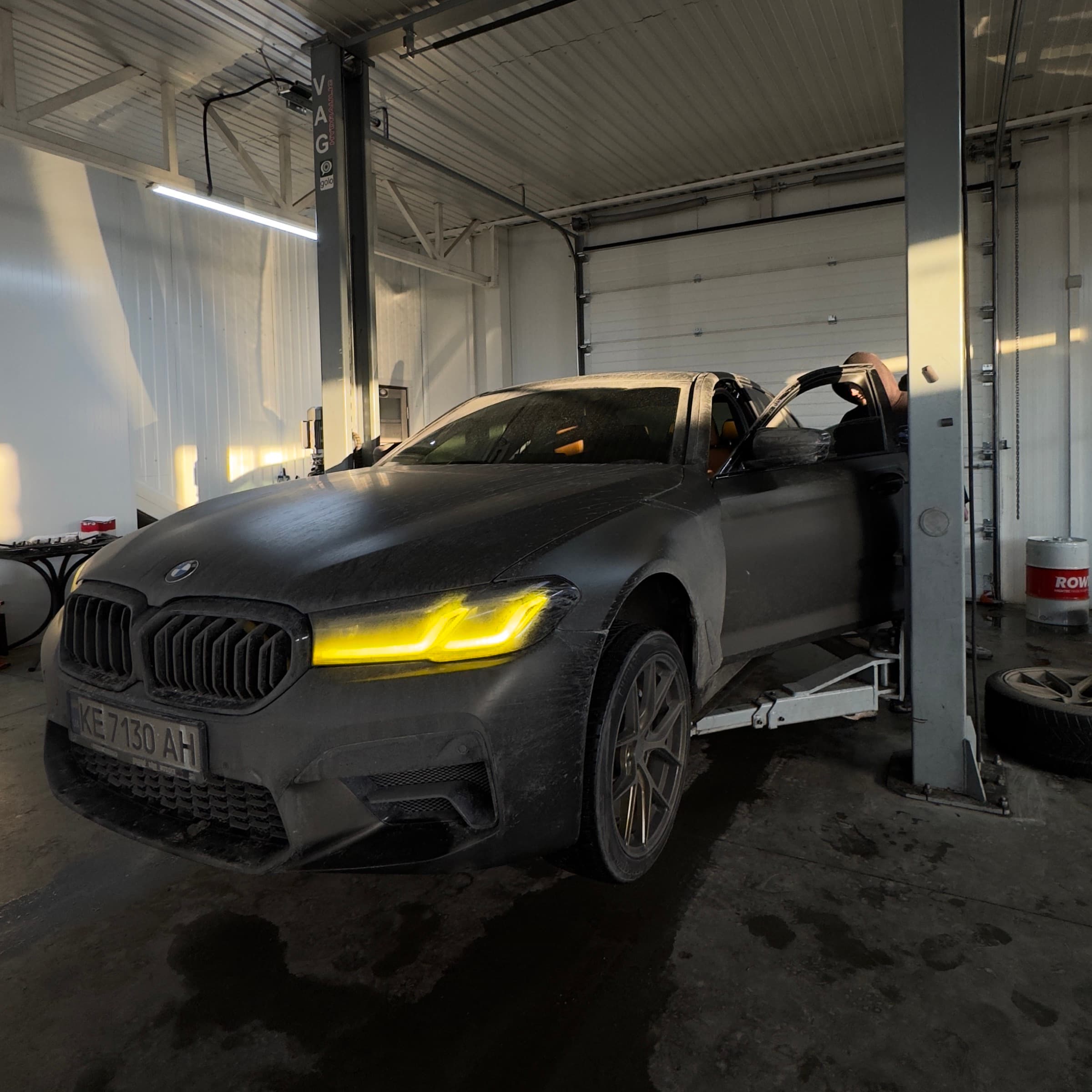 BMW 5 серії в матовій плівці в цеху на заході сонця