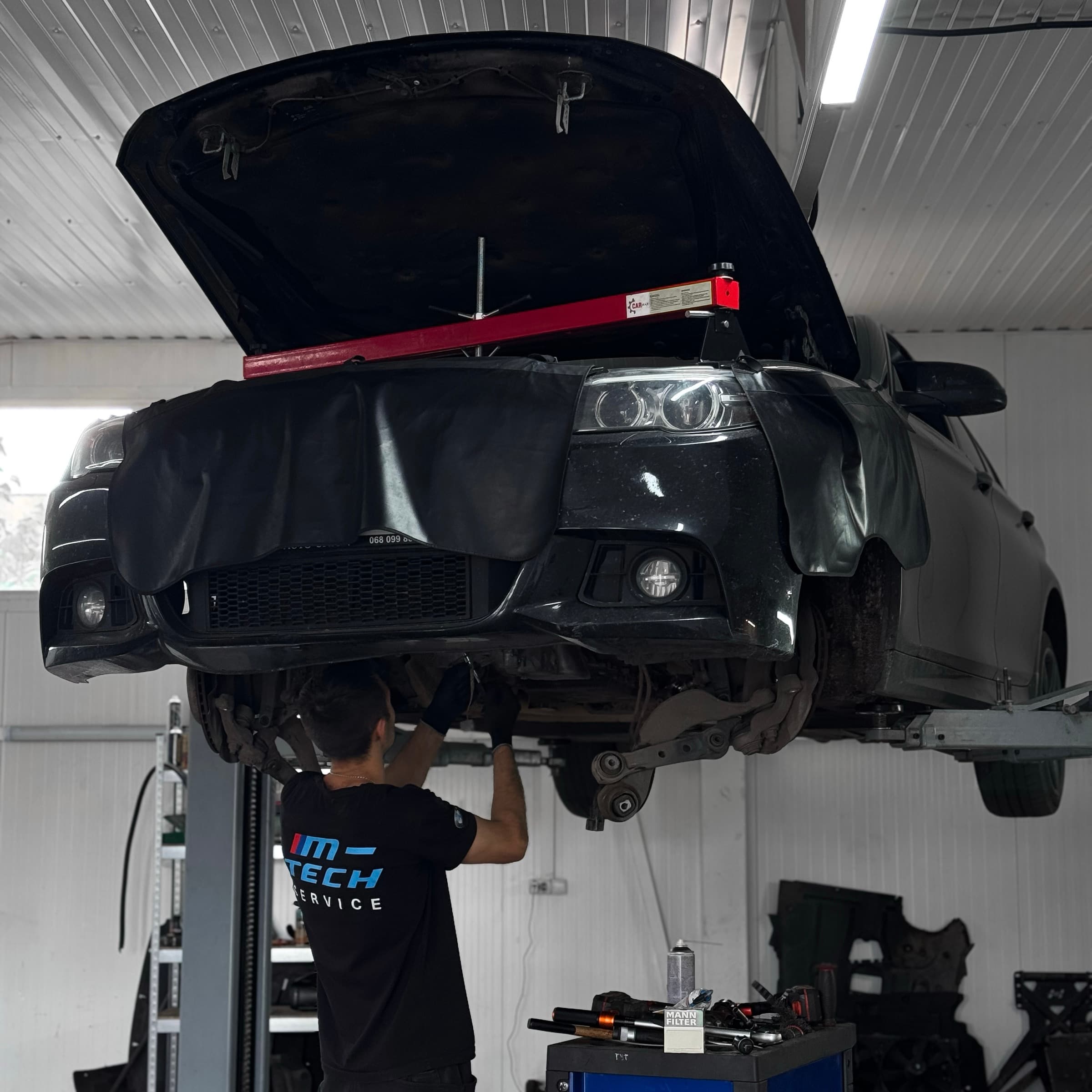 BMW на підйомнику в цеху M-Tech, майстер під авто